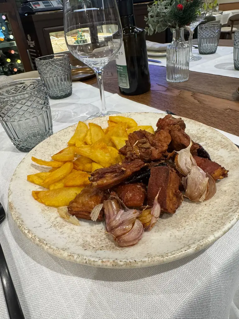 Cochifrito con ajos y patatas en el comedor del Restaurante Tres Hermanos