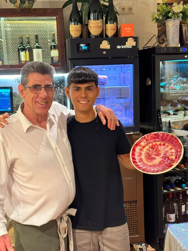 El equipo del Restaurante Tres Hermanos con un plato de jamón ibérico
